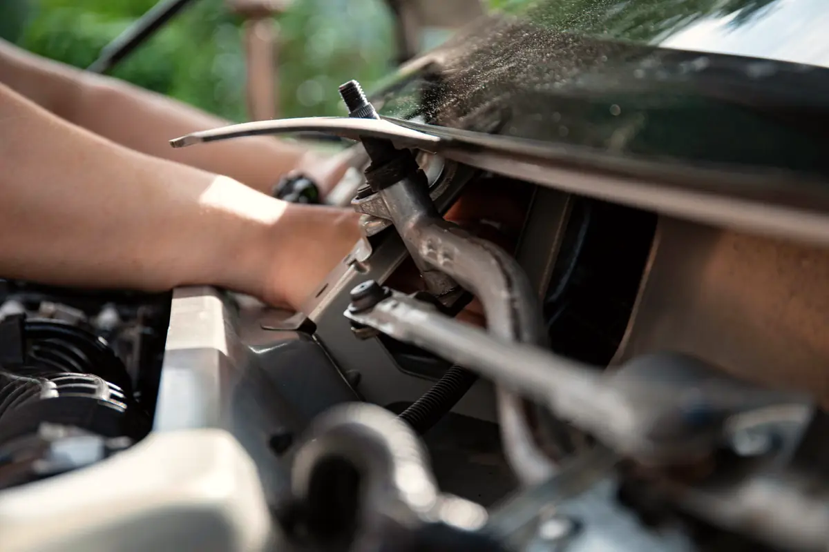 Manos de un mecánico trabajando en un motor
